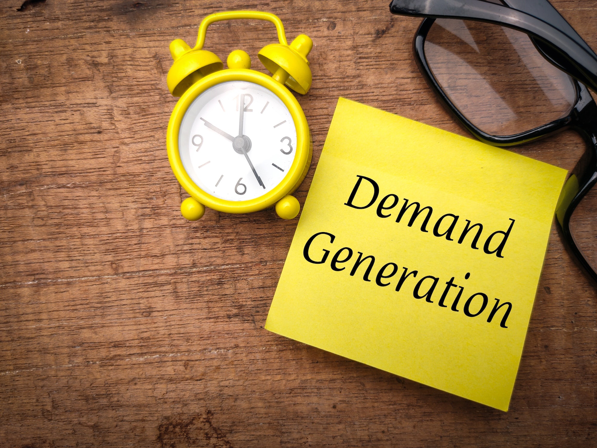 Glasses and alarm clock with the word Demand Generation