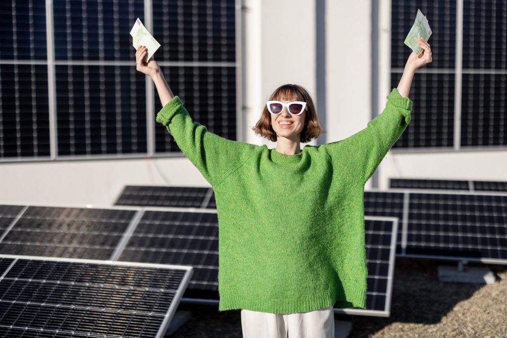 Happy household owner with money near solar power plant